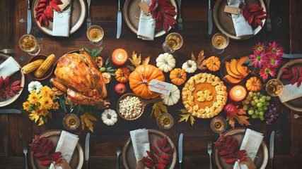 Thanksgiving dinner table set with seasonal dishes and autumn decorations