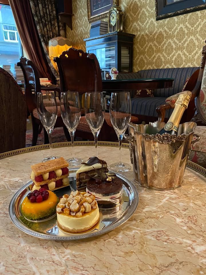Antique interior of Art Cafe Sienna with cakes, pastries, champagne flutes and gold damask walls