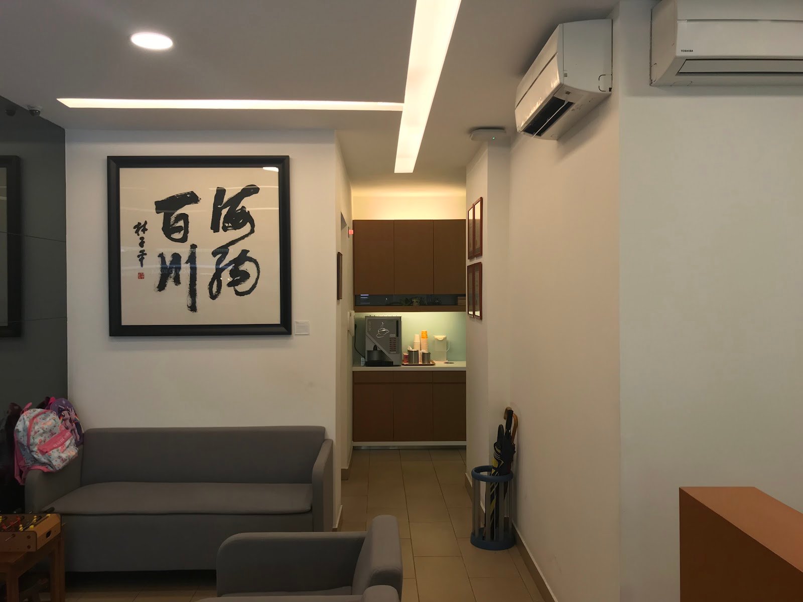 Waiting area at Friends Dental Surgeons in Tampines East, with seating, wood cabinetry, and a bright clinic interior