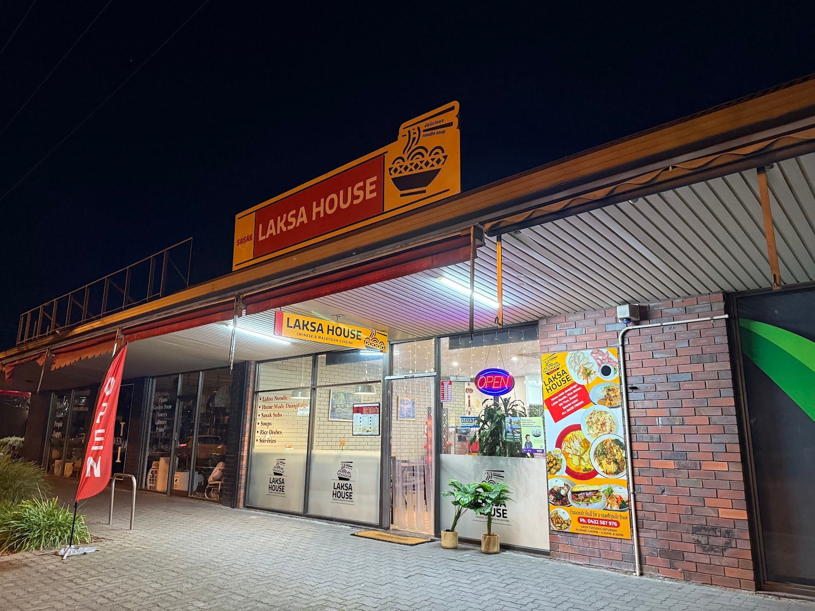 Night-time storefront of Sasak Laksa House at 15 Darlot Street, Horsham, with Chinese and Malaysian cuisine signage, a yellow rooftop sign, and an OPEN neon light