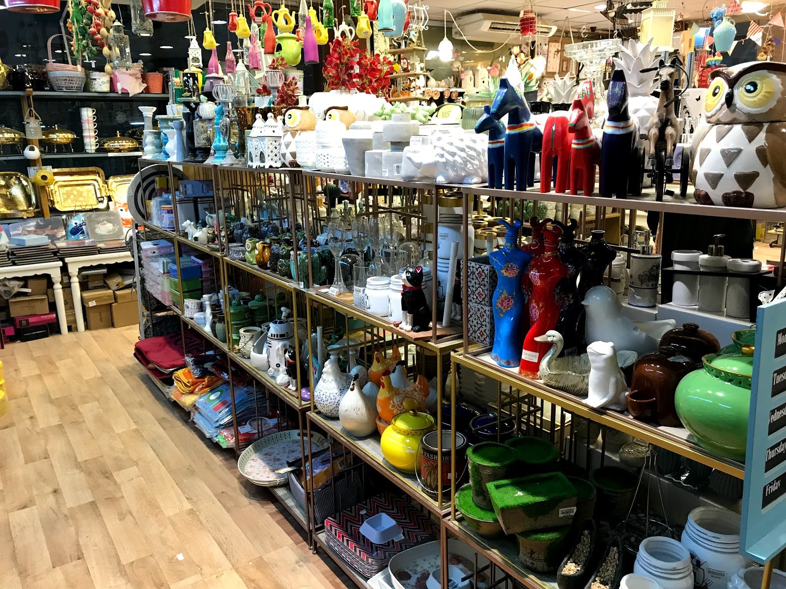 Giftware, ceramics and home decor displayed on gold-framed shelves in Taiba Market